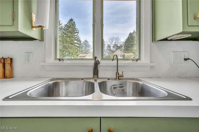 details featuring green cabinets and sink