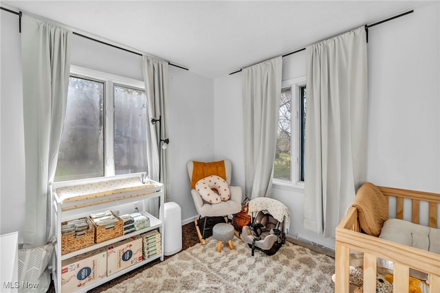 carpeted bedroom featuring a crib