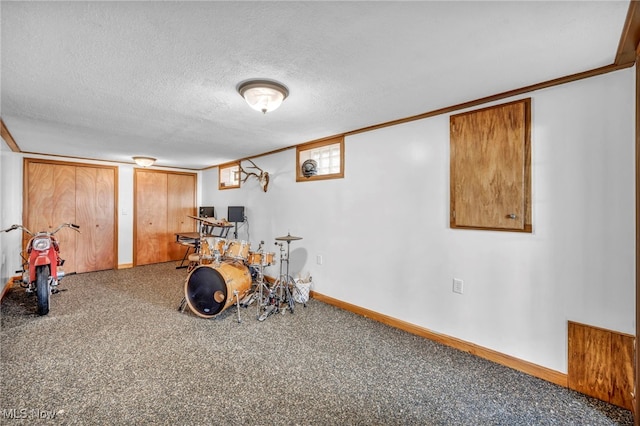 rec room with carpet, a textured ceiling, and ornamental molding