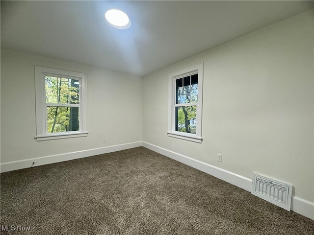 spare room featuring dark carpet