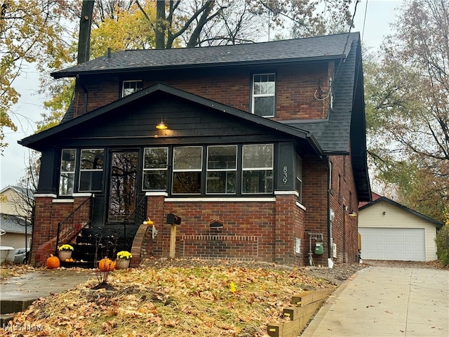 view of front of home featuring a garage and an outbuilding