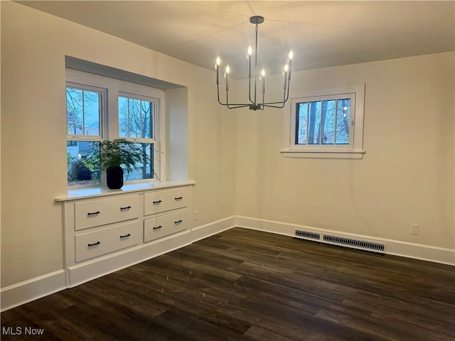 unfurnished dining area with dark wood-type flooring and a notable chandelier