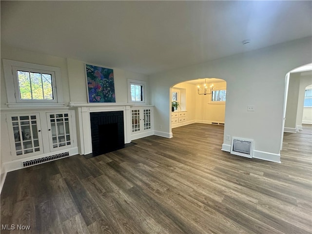 unfurnished living room with hardwood / wood-style floors and an inviting chandelier