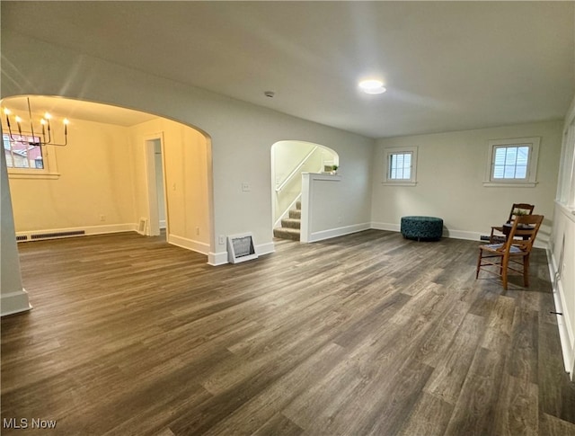 interior space with a notable chandelier and dark wood-type flooring