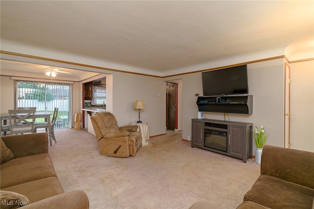 living room featuring ceiling fan, ornamental molding, and light carpet