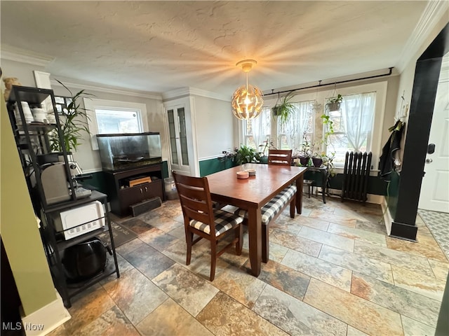 dining room featuring ornamental molding and a notable chandelier