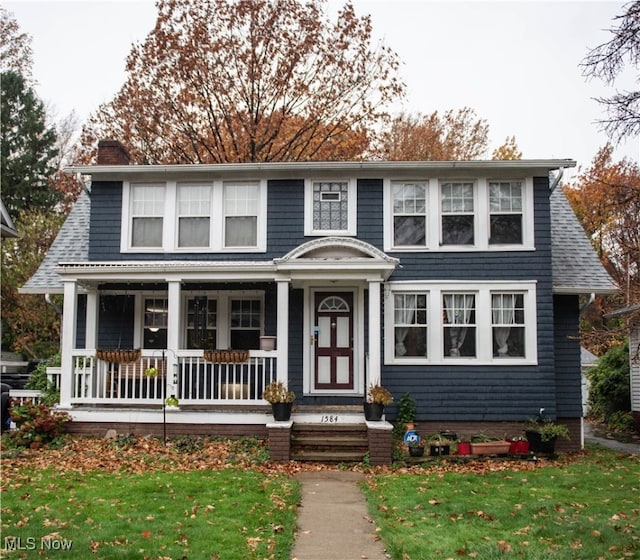 view of front of home featuring covered porch and a front yard