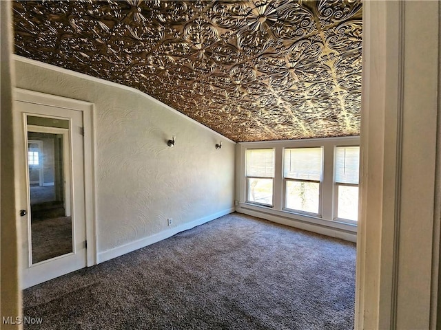 carpeted empty room with baseboards, ornamental molding, a textured wall, and an ornate ceiling