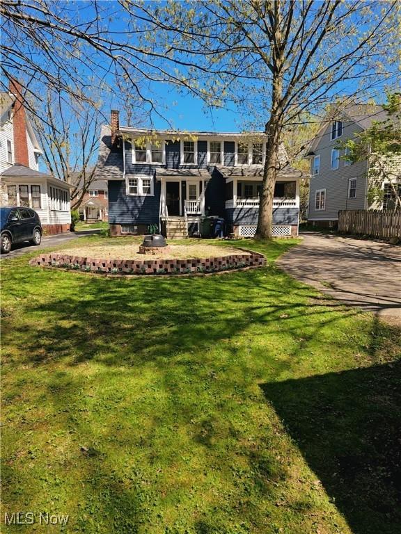 view of front of home with fence, a front yard, and a chimney