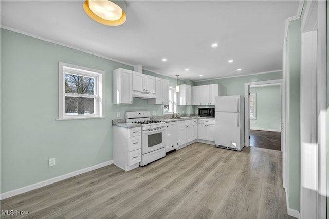 kitchen with white cabinets, pendant lighting, white appliances, and light hardwood / wood-style flooring