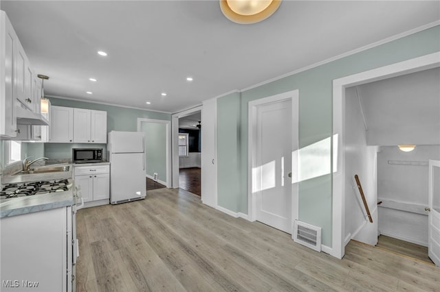 kitchen with light hardwood / wood-style flooring, white cabinets, decorative light fixtures, and white appliances