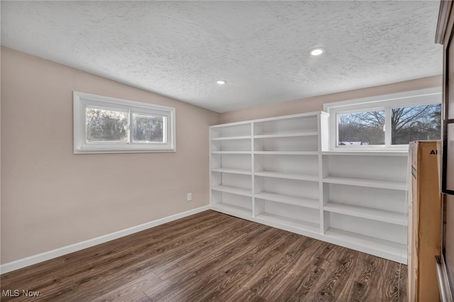 spare room with dark hardwood / wood-style floors and a textured ceiling