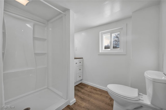 bathroom featuring vanity, toilet, wood-type flooring, and walk in shower