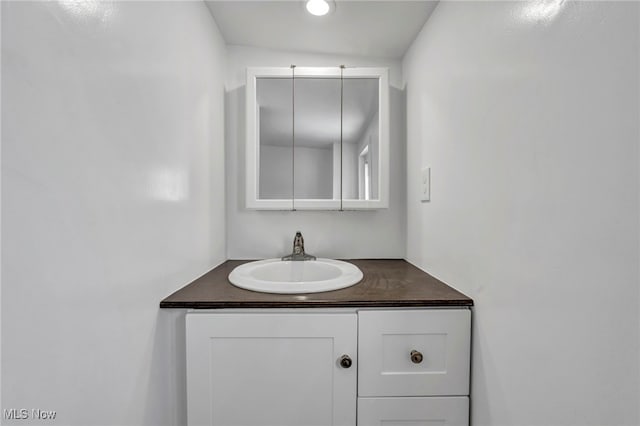 bathroom featuring vanity and lofted ceiling