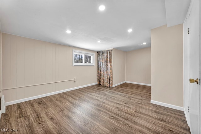 basement with hardwood / wood-style floors and wood walls