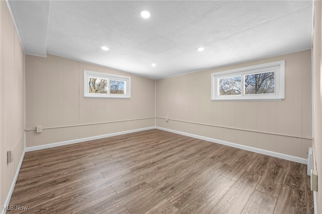 basement with a healthy amount of sunlight and wood-type flooring