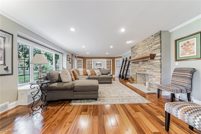 living room featuring a fireplace, wood-type flooring, and ornamental molding