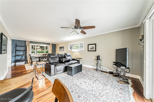 living room with hardwood / wood-style flooring, ceiling fan, and crown molding