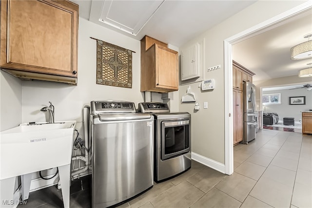 clothes washing area featuring ceiling fan, sink, cabinets, separate washer and dryer, and light tile patterned flooring