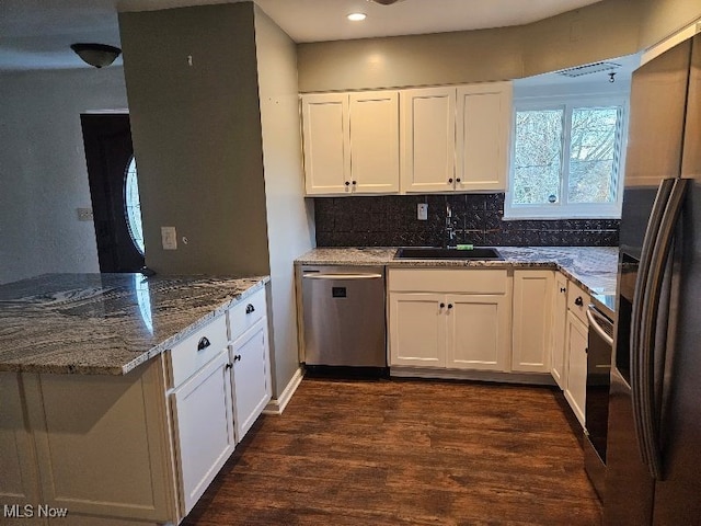 kitchen with stone counters, white cabinets, sink, dark hardwood / wood-style floors, and appliances with stainless steel finishes