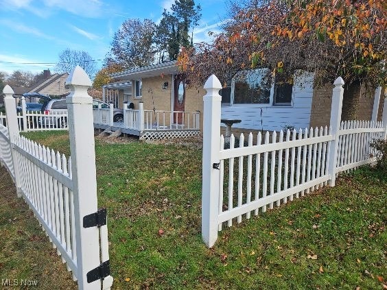 view of side of property featuring a lawn and a deck