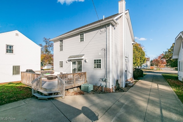 rear view of property with a deck and central air condition unit