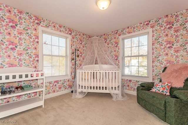 carpeted bedroom featuring a crib and multiple windows