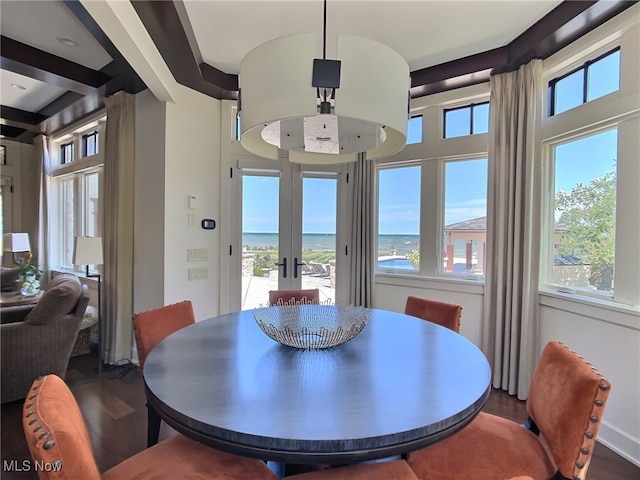 dining space with a water view, wood-type flooring, and french doors