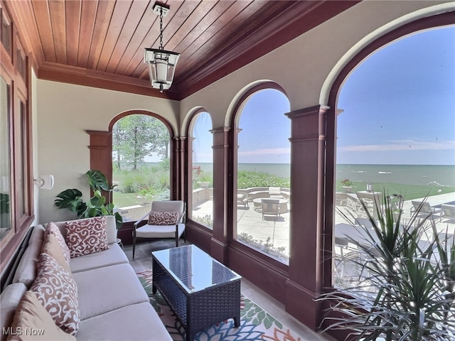 sunroom featuring a healthy amount of sunlight, a water view, and wood ceiling