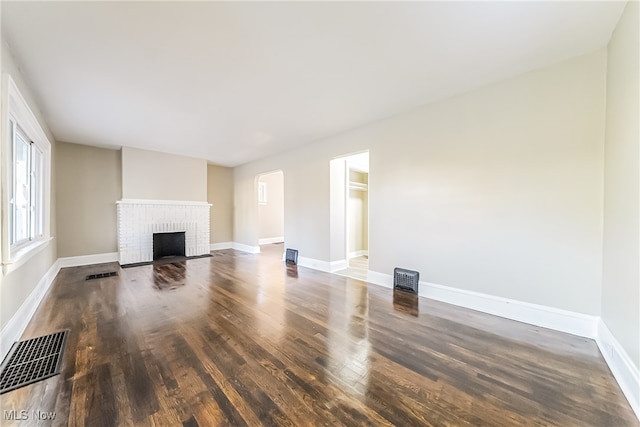 unfurnished living room with a fireplace and dark hardwood / wood-style flooring