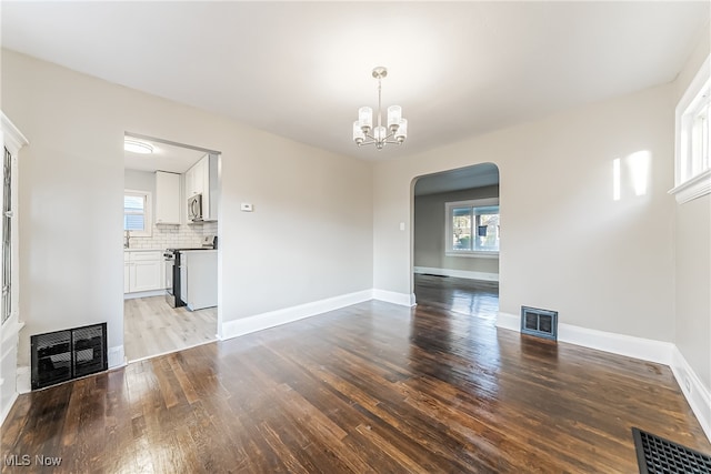 unfurnished dining area with a chandelier, a wealth of natural light, and light hardwood / wood-style floors