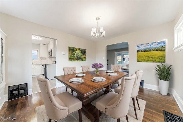 dining space featuring a wealth of natural light, dark hardwood / wood-style flooring, and a chandelier