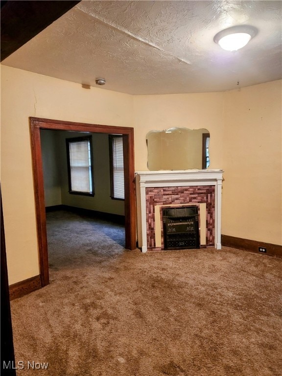 unfurnished living room featuring carpet floors and a textured ceiling