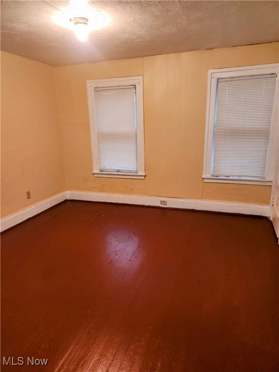 empty room featuring wood-type flooring and a textured ceiling