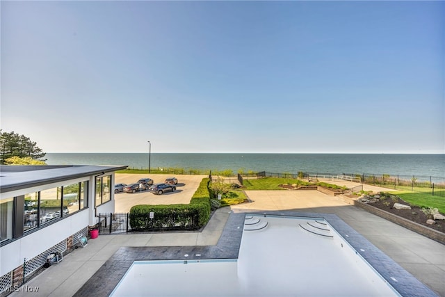 view of pool featuring a water view and a patio