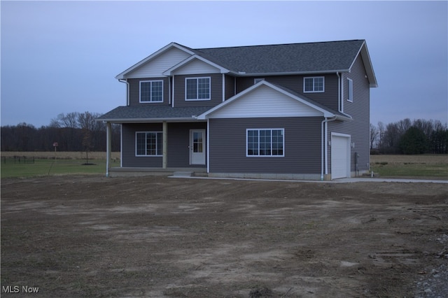 front of property featuring covered porch and a garage