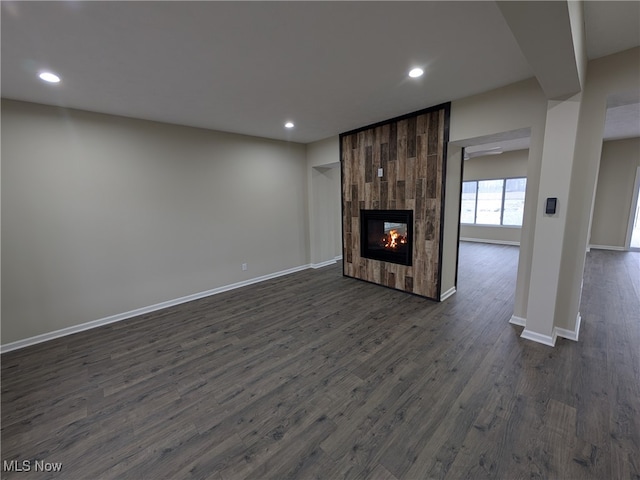 unfurnished living room with dark hardwood / wood-style flooring and a large fireplace