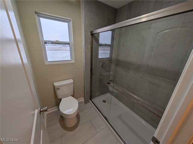 bathroom featuring tile patterned floors, toilet, and walk in shower