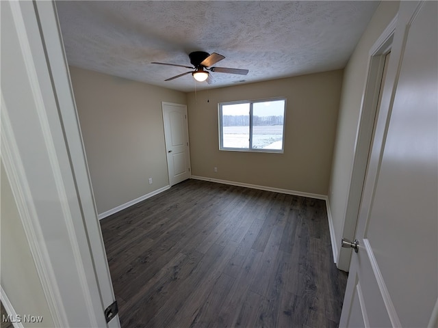 empty room featuring a textured ceiling, dark hardwood / wood-style flooring, and ceiling fan