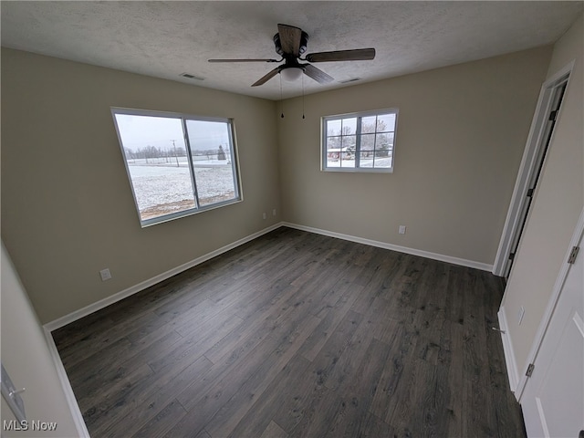 empty room with ceiling fan, dark hardwood / wood-style flooring, and a textured ceiling