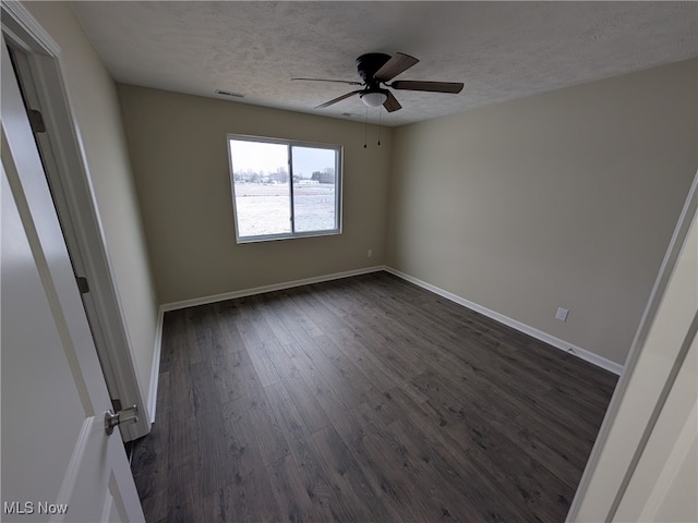 spare room with a textured ceiling, ceiling fan, and dark wood-type flooring