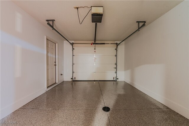 garage with a garage door opener and baseboards