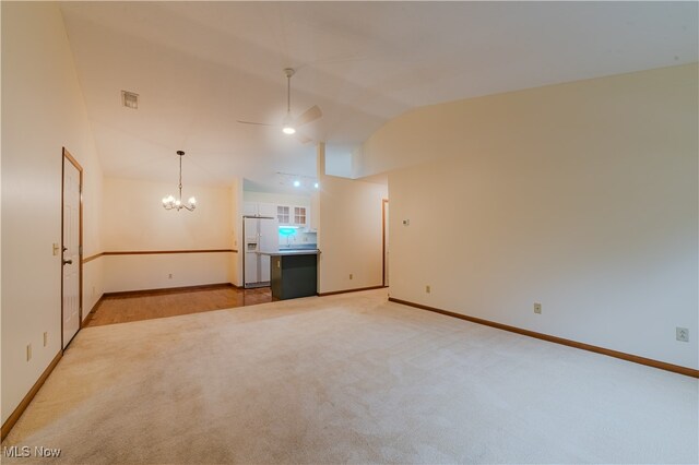 unfurnished room with ceiling fan with notable chandelier, baseboards, visible vents, and light colored carpet