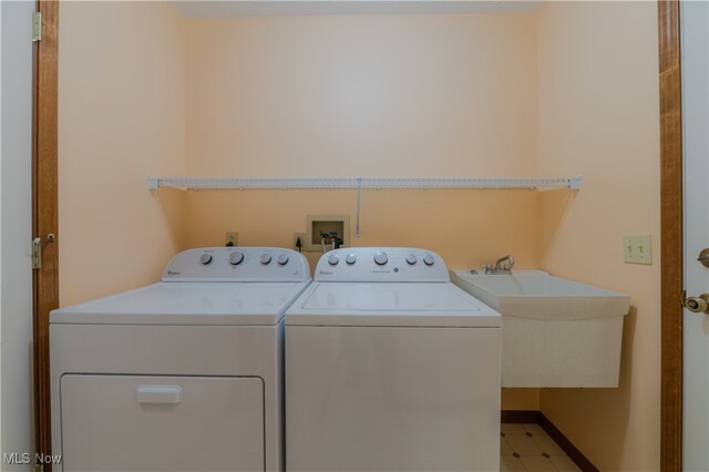 washroom featuring a sink, laundry area, and washing machine and dryer