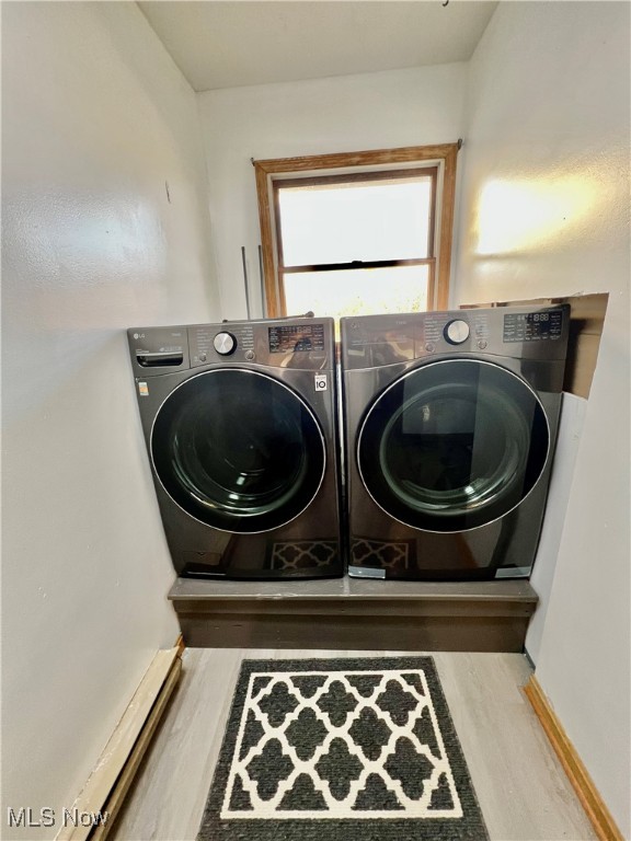 laundry room with hardwood / wood-style floors and washing machine and dryer