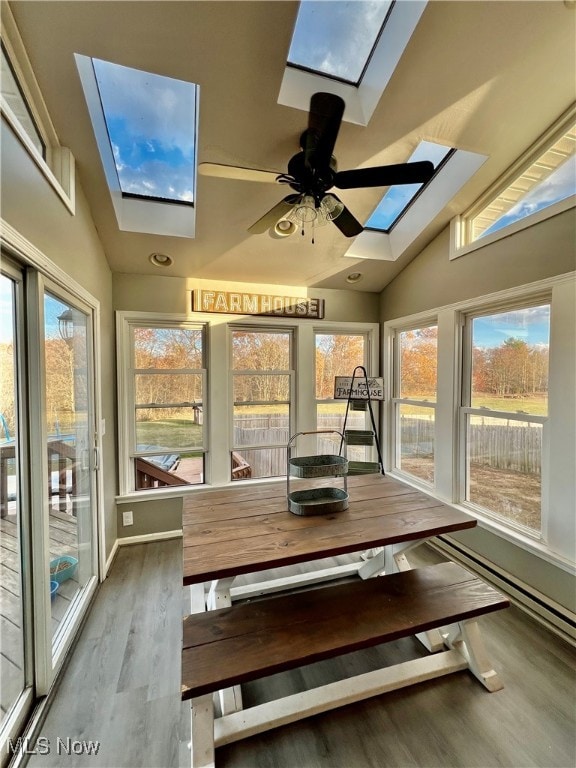 unfurnished sunroom with lofted ceiling with skylight and ceiling fan