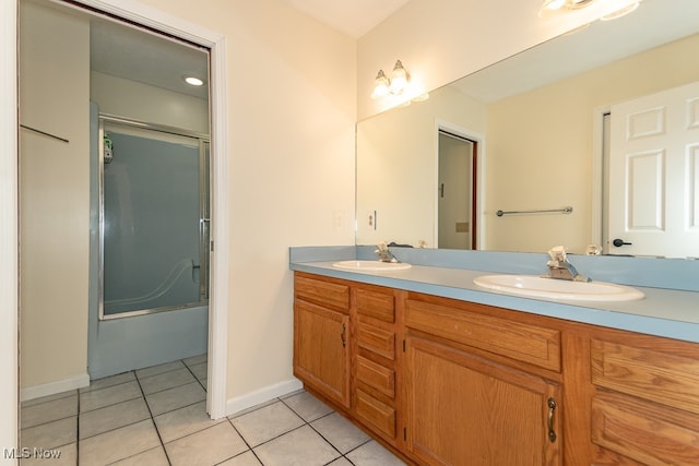 bathroom featuring tile patterned flooring, vanity, and enclosed tub / shower combo