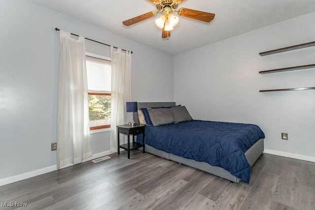 bedroom with ceiling fan and dark wood-type flooring