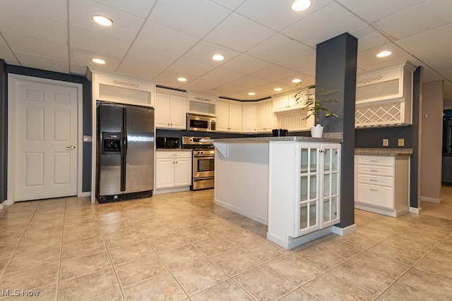 kitchen with white cabinets, stainless steel appliances, and light tile patterned floors