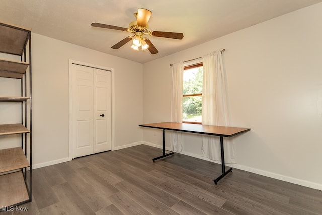 unfurnished office with dark hardwood / wood-style floors and ceiling fan